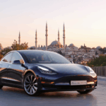 Gün ışığında modern Türk mimarisi önünde park eden şık Tesla Model 3 Highland, elektrikli otomobil tasarımı ve kentsel ortam.